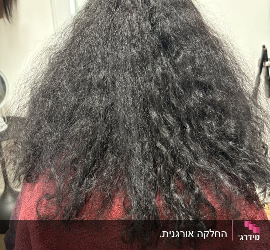שיער מתולתל במספרה עם מגבת אדומה